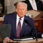 Donald Trump speaking at a White House event with U.S. flags in the background, suggesting a trade deal announcement.