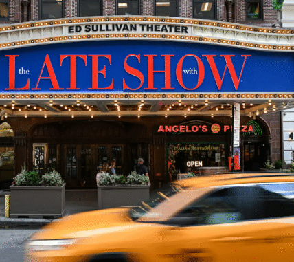 Stephen Colbert on the set of The Late Show, engaging with the studio audience during a taping.