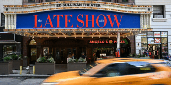 Stephen Colbert on the set of The Late Show, engaging with the studio audience during a taping.